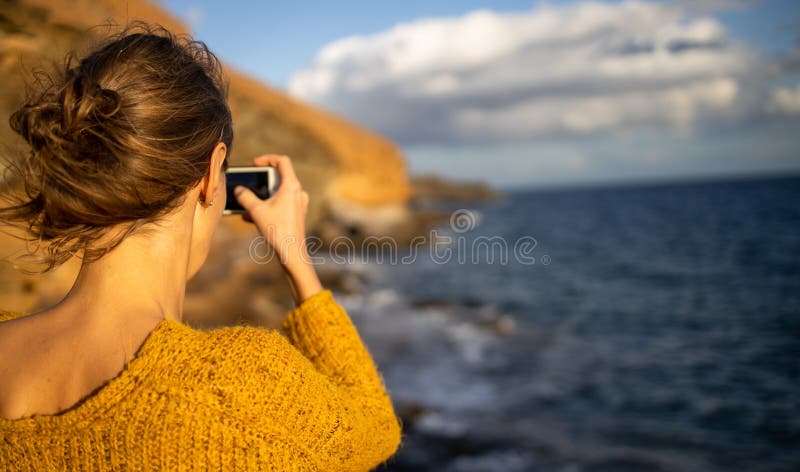красивая молодая женщина фотографирует с смартфона стоковая фотография