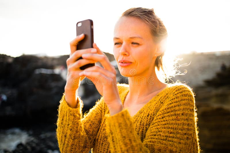 красивая молодая женщина фотографирует с смартфона стоковые фотографии rf