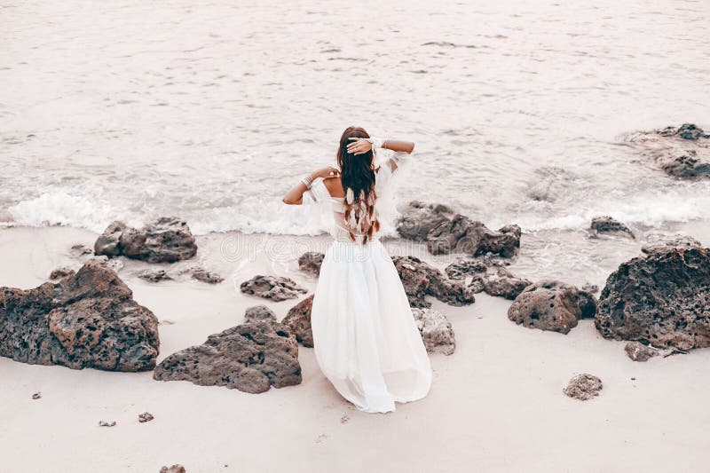 Красивая молодая стильная женщина boho на пляже на заходе солнца стоковые изображения rf