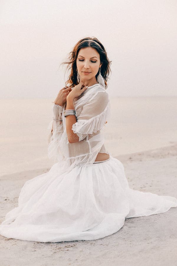 Красивая молодая стильная женщина boho сидя на пляже на sunse стоковые изображения rf