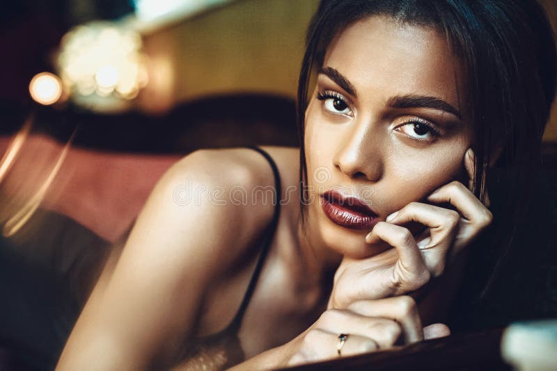 Красивая темнокожая молодая женщина sensualy представляя в черном женском белье r стоковые фото