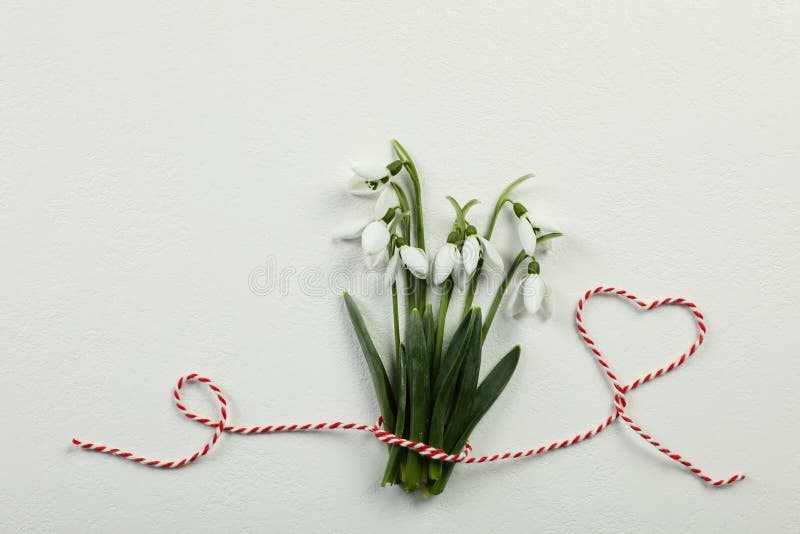Красивые snowdrops с традиционным мэрцишор шнура на белом фоне плоском и помещение для текста. Символ первого весеннего дня стоковое изображение rf