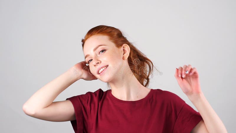 Красивые молодые танцы девушки redhead и смотреть камеру на белой предпосылке движение медленное сток-видео