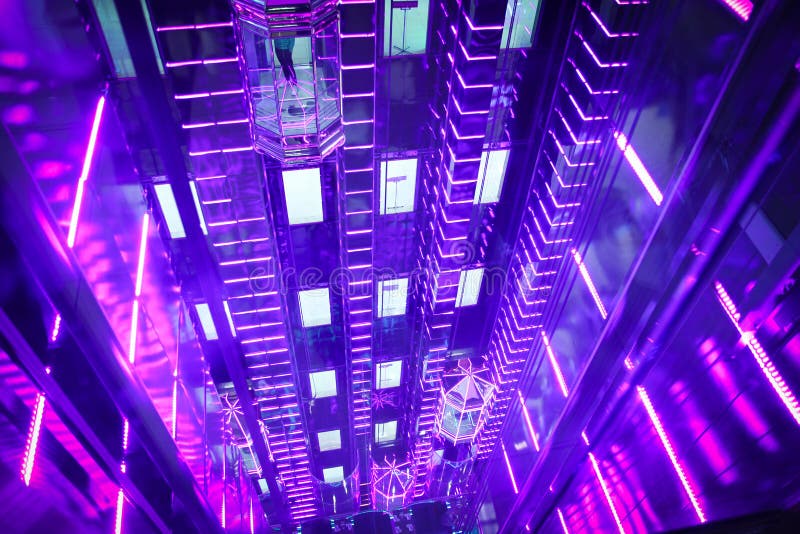 Красивые стеклянные фиолетовые лифты в торговом центре Москвы
