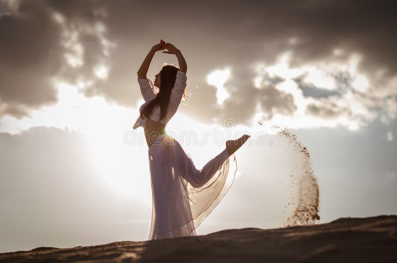 Beautiful woman dancing on the beach at the sunrise. Beautiful woman dancing on the beach at the sunrise