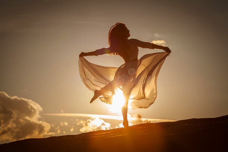 Beautiful woman dancing on the beach at the sunset. Beautiful woman dancing on the beach at the sunset