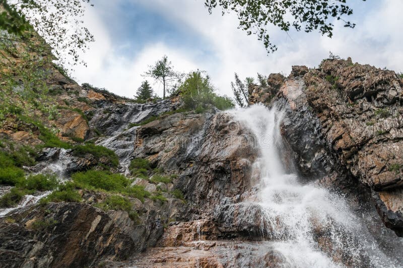 Красивый водопад на утесах в горах Altai стоковое фото rf Красивый водопад на утесах в горах Altai стоковое фото rf