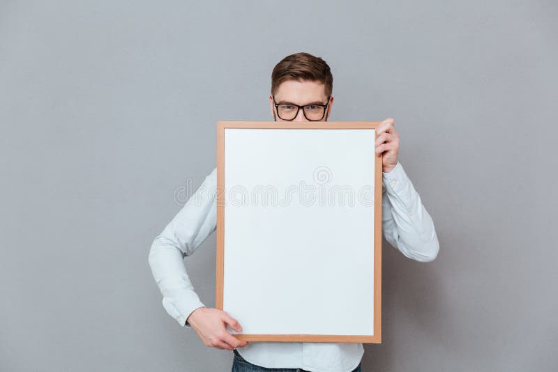 Красивый молодой бородатый бизнесмен держа доску copyspace стоковая фотография