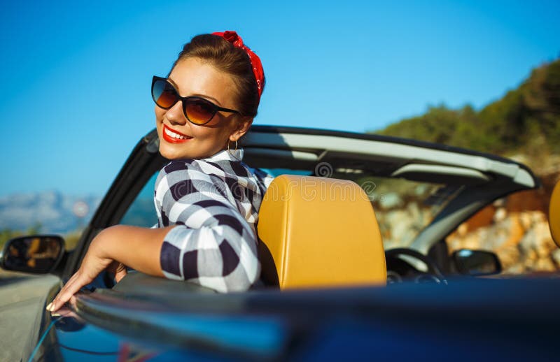 Красивый штырь вверх по женщине сидя в cabriolet, наслаждаясь отключением на lu стоковая фотография Красивый штырь вверх по женщине сидя в cabriolet, наслаждаясь отключением на lu стоковая фотография