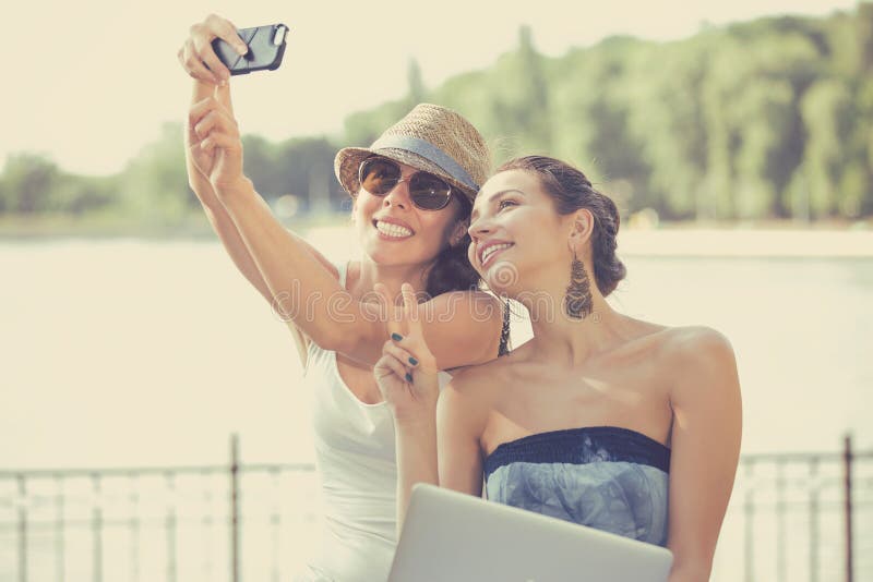 2 красивых молодой женщины делая смеяться над selfie стоковая фотография rf