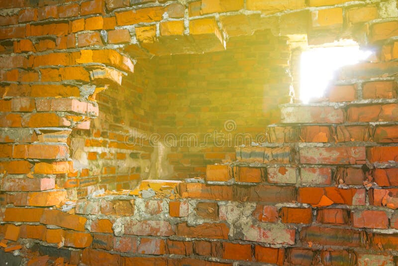 Closeup red brick wall with hole lightened by a sun. Closeup red brick wall with hole lightened by a sun