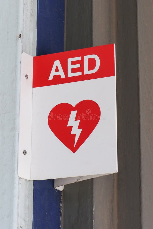 Красный цвет и автоматизированные белизной внешние AED дефибриллятора подписывают внутри общественное место стоковое изображение rf Красный цвет и автоматизированные белизной внешние AED дефибриллятора подписывают внутри общественное место стоковое изображение rf