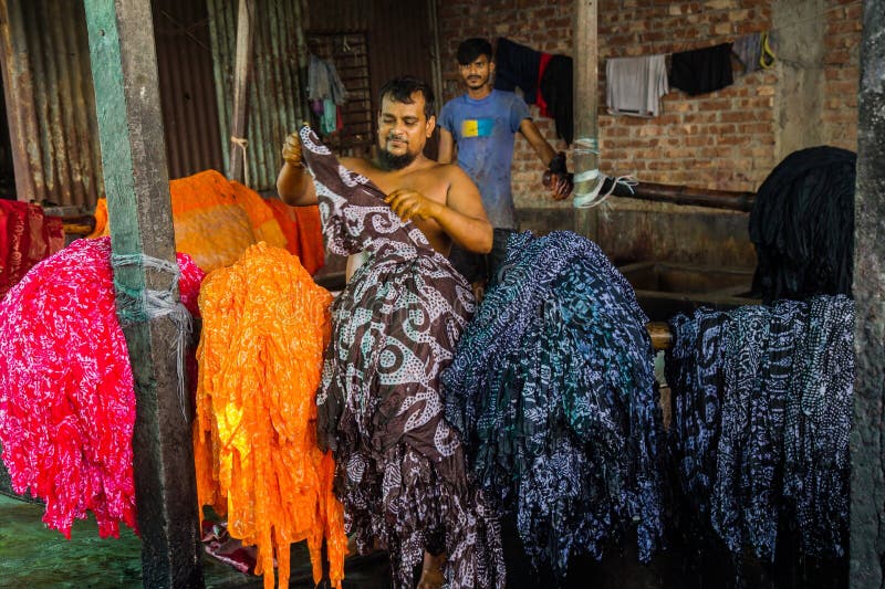 Waves of every color swaying in the wind , and a sweet scent of freshly cut fabric everywhere. It seems the waves of color extended towards horizon. This scene is from Narayanganj's Araihajar Banti, Rupganj's Noagaon and Chanpara villages.A village which once was surrounded by scarcity, its children could not go to school as their parents were unable to pay the fees, now changed the scenario up side down and become a role model for the whole country. Now the families of these villages associated with batik business are earning Tk 2,160 crores annually.Banti village is only 32 km away from Dhaka. All those three villages including Banti are now famous for batik. Batik cloths of three villages are sold in Banti Bazar. Abdul Hai Bhuiyan, President of Banti Bazaar Traders Association, said that batik business started in this market in 1981. At present it has turned into a hub. There are 22 small and big markets on both sides of this hub. There are almost 2500 shops in these markets. Right now 1,500 shops are in operation. The rest of the shops will also open before the next holy month of Ramadan and Pahela Baisakh. Each of the 1,500 shops sell an average of Tk 40,000 worth of batik goods per day. According to that, there is a business of 180 crore rupees per month. And the annual business is 2 thousand 160 crore Taka.From dawn to dusk, the men and women of these villages are busy making batik. As far as the eye can see, cloths painted in various traditional designs are seen hanging on ropes. Residents of the village are dyeing clothes in the yard, side roads, land or open fields, some are blocking, others are drying wet clothes in the sun. Waves of every color swaying in the wind , and a sweet scent of freshly cut fabric everywhere. It seems the waves of color extended towards horizon. This scene is from Narayanganj's Araihajar Banti, Rupganj's Noagaon and Chanpara villages.A village which once was surrounded by scarcity, its children could not go to school as their parents were unable to pay the fees, now changed the scenario up side down and become a role model for the whole country. Now the families of these villages associated with batik business are earning Tk 2,160 crores annually.Banti village is only 32 km away from Dhaka. All those three villages including Banti are now famous for batik. Batik cloths of three villages are sold in Banti Bazar. Abdul Hai Bhuiyan, President of Banti Bazaar Traders Association, said that batik business started in this market in 1981. At present it has turned into a hub. There are 22 small and big markets on both sides of this hub. There are almost 2500 shops in these markets. Right now 1,500 shops are in operation. The rest of the shops will also open before the next holy month of Ramadan and Pahela Baisakh. Each of the 1,500 shops sell an average of Tk 40,000 worth of batik goods per day. According to that, there is a business of 180 crore rupees per month. And the annual business is 2 thousand 160 crore Taka.From dawn to dusk, the men and women of these villages are busy making batik. As far as the eye can see, cloths painted in various traditional designs are seen hanging on ropes. Residents of the village are dyeing clothes in the yard, side roads, land or open fields, some are blocking, others are drying wet clothes in the sun.