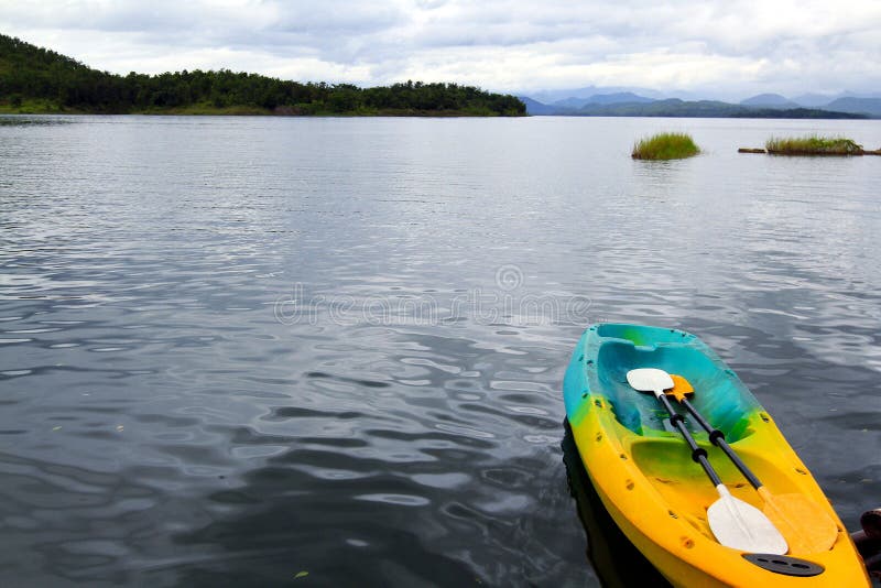 Красочная шлюпка canoeing или каяка с затвором 2 плавая на озеро стоковое фото Красочная шлюпка canoeing или каяка с затвором 2 плавая на озеро стоковое фото