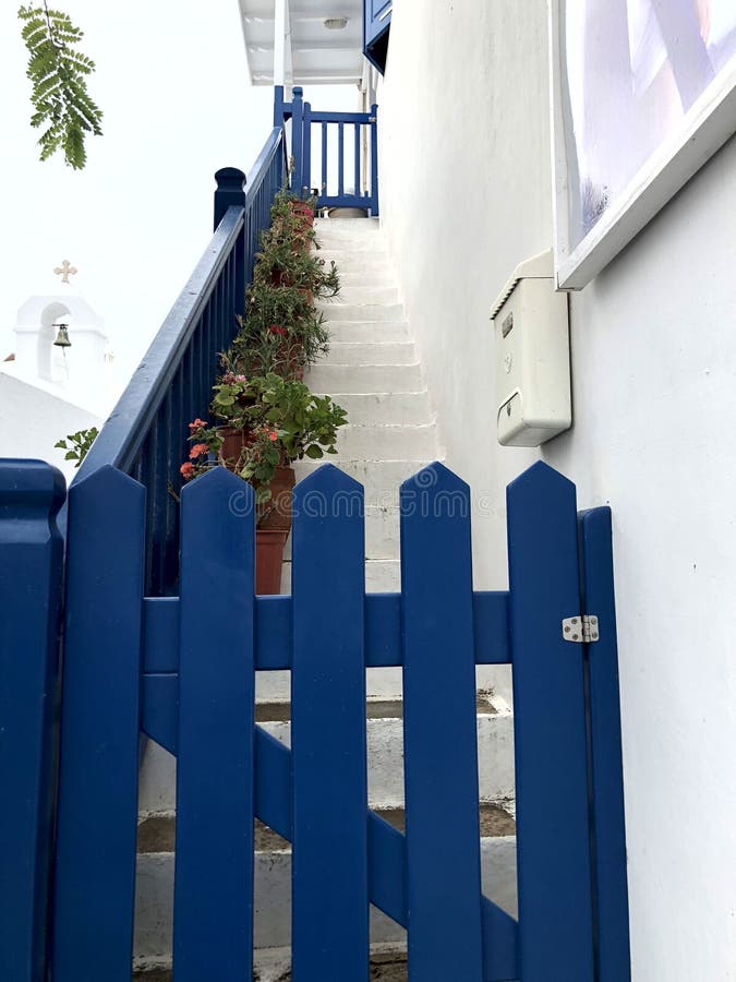 Красочные белые улицы с голубыми дверями и окна на острове Mykonos стоковое изображение Красочные белые улицы с голубыми дверями и окна на острове Mykonos стоковое изображение