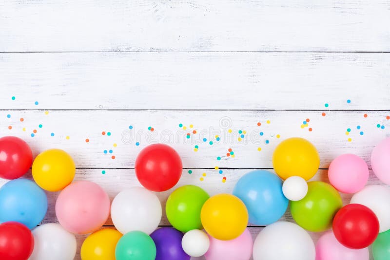 Красочные воздушные шары и confetti на белом взгляде столешницы r r o стоковые фотографии rf Красочные воздушные шары и confetti на белом взгляде столешницы r r o стоковые фотографии rf