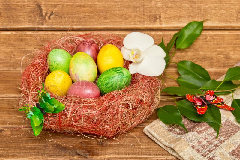 Красочные пасхальные яйца в гнезде на деревянной предпосылке Eggs handmade новый стиль расцветки стоковые фотографии rf Красочные пасхальные яйца в гнезде на деревянной предпосылке Eggs handmade новый стиль расцветки стоковые фотографии rf