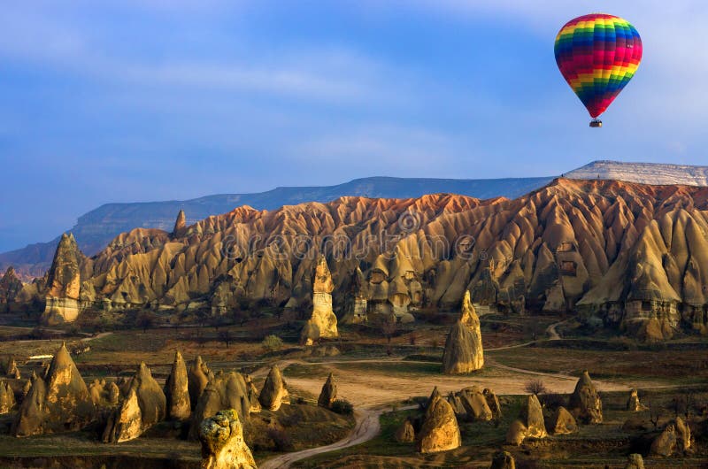 Красочный горячий воздушный шар летая над betwitching ландшафтом Cappadocia, Турции стоковые фотографии rf Красочный горячий воздушный шар летая над betwitching ландшафтом Cappadocia, Турции стоковые фотографии rf