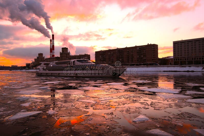 A cruise touristic ship sails on the river at sunset. Color winter photo. A cruise touristic ship sails on the river at sunset. Color winter photo.