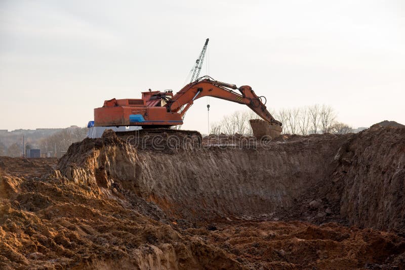 Крупная операция экскаватора на стройке. Экскаватор во время earthworks на карьере песка. Earthmoving тяжелое оборудование стоковое изображение rf