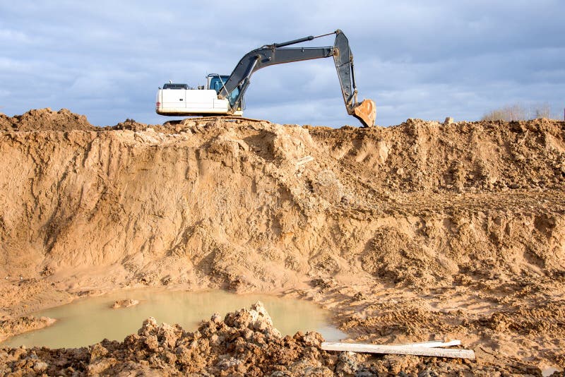 Крупная операция экскаватора на стройке. Экскаватор во время earthworks на карьере песка. Earthmoving тяжелое оборудование стоковые изображения