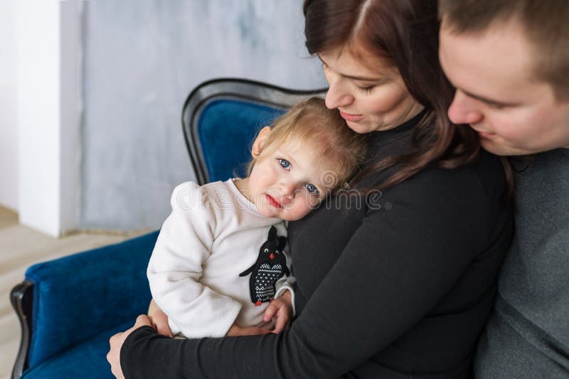 Крупный план маленькой девочки в объятиях родителей Портрет счастливой персоны семьи из трех человек стоковые изображения