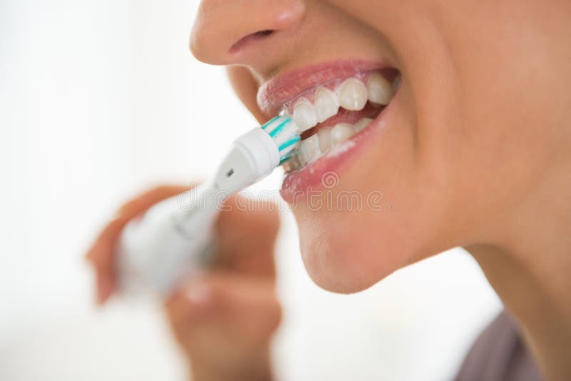 Closeup on young woman brushing teeth in bathroom. Closeup on young woman brushing teeth in bathroom