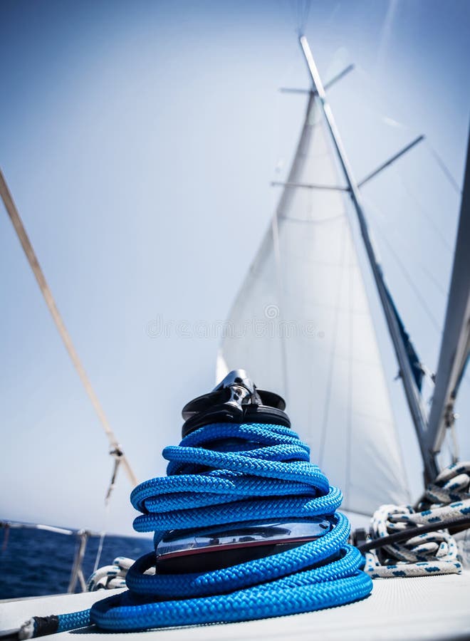 Closeup on yacht cord crank, rope holder on white sail background, yachting sport, sailboat detail, luxury water transport, summer vacation concept. Closeup on yacht cord crank, rope holder on white sail background, yachting sport, sailboat detail, luxury water transport, summer vacation concept