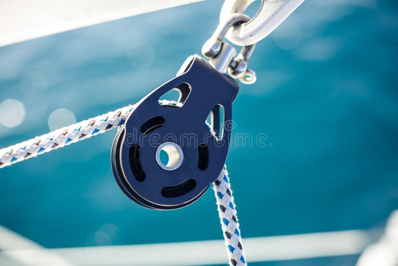 Closeup on yacht cord crank, rope holder on white sail background. Closeup on yacht cord crank, rope holder on white sail background