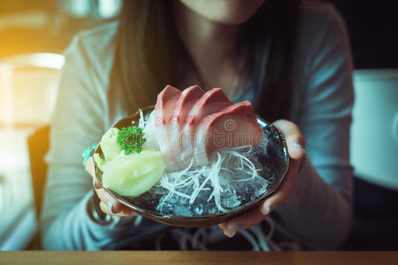 Крупный план женщины руки держа набор Hamachi тунца, японскую кухню в традиционной Японии стоковое изображение Крупный план женщины руки держа набор Hamachi тунца, японскую кухню в традиционной Японии стоковое изображение