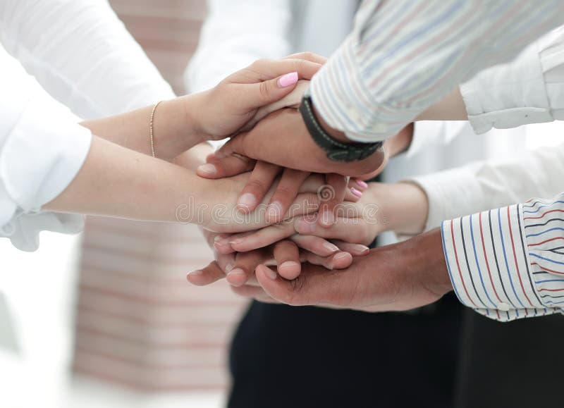 Closeup of business team putting their hands on top of each other.concept of teamwork. Closeup of business team putting their hands on top of each other.concept of teamwork.