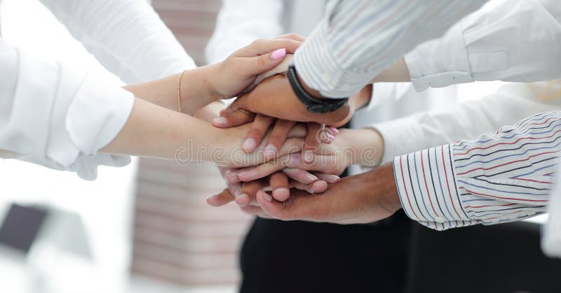 Closeup of business team putting their hands on top of each other.concept of teamwork. Closeup of business team putting their hands on top of each other.concept of teamwork.