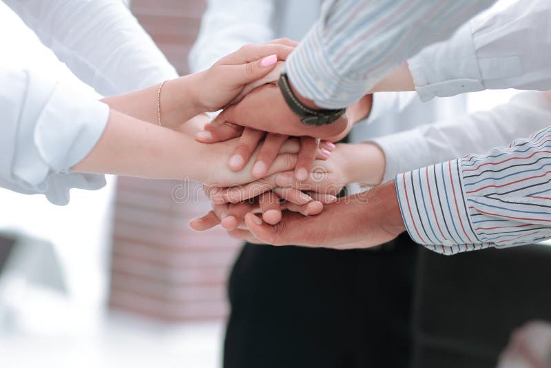 Closeup of business team putting their hands on top of each other.concept of teamwork. Closeup of business team putting their hands on top of each other.concept of teamwork.