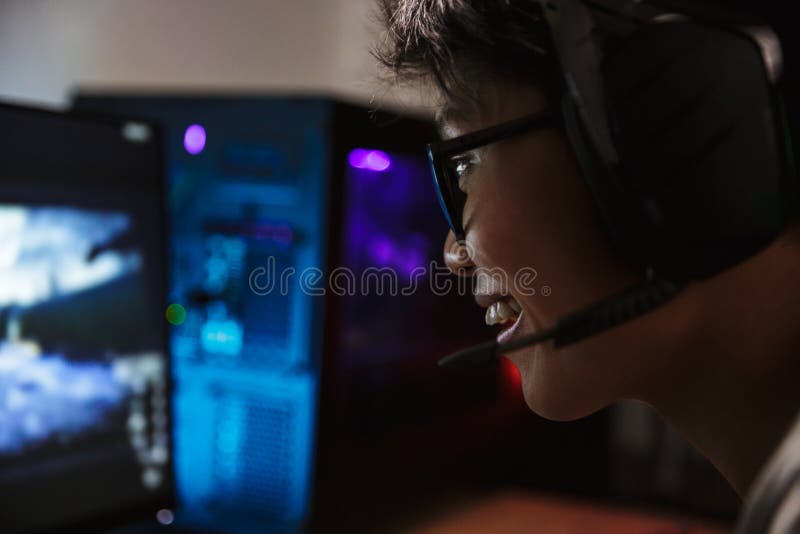 Крупный план фото азиатского довольного мальчика gamer играя onl видеоигр стоковое изображение rf Крупный план фото азиатского довольного мальчика gamer играя onl видеоигр стоковое изображение rf