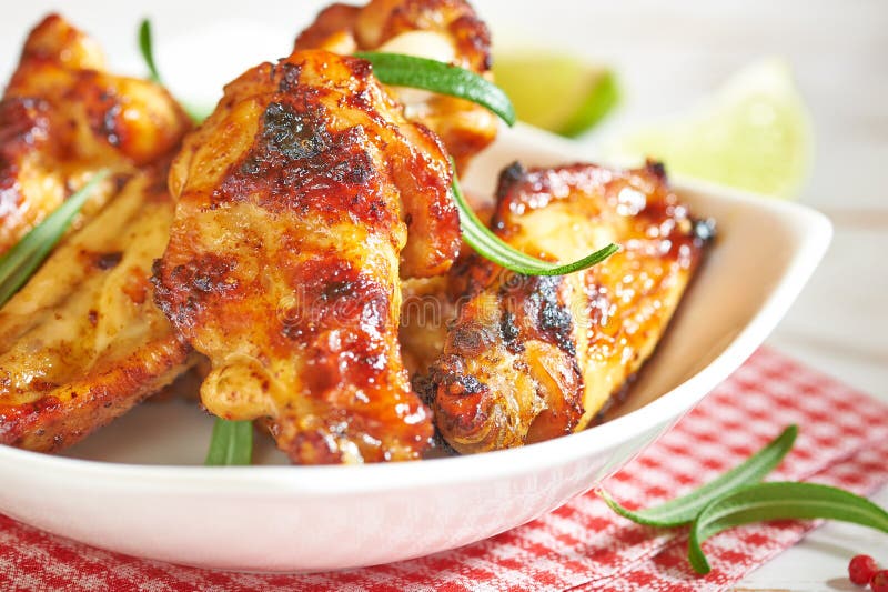 Teriyaki chicken wings. Baked chicken with fresh rosemary. Homemade food. Symbolic image. Concept for a tasty and healty dish. Bright wooden background. Close up. Teriyaki chicken wings. Baked chicken with fresh rosemary. Homemade food. Symbolic image. Concept for a tasty and healty dish. Bright wooden background. Close up.