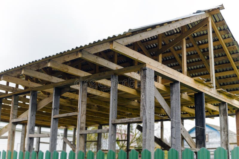 a frame and roof of unfinished outbuilding made of wood, outdoor shot. a frame and roof of unfinished outbuilding made of wood, outdoor shot