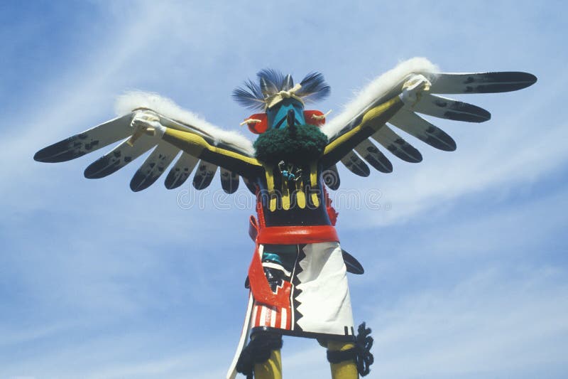 Hopi Kachina doll with outstretched winged arms against blue sky. Hopi Kachina doll with outstretched winged arms against blue sky
