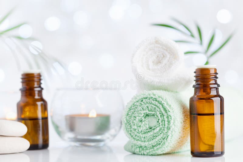 Spa, aromatherapy, wellness, beauty background. Essential oil bottle, towel and candles on table. Spa, aromatherapy, wellness, beauty background. Essential oil bottle, towel and candles on table.