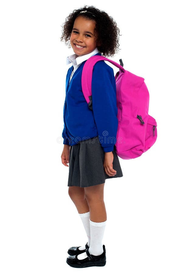 Curly haired elementary school girl carrying pink backpack on shoulders. Curly haired elementary school girl carrying pink backpack on shoulders.