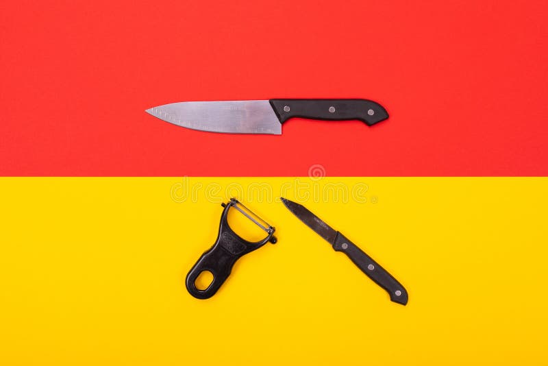 Кухонный нож и peeler изолированы на желт-красной предпосылке стоковое изображение rf