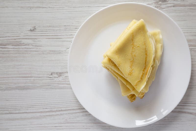 Куча вкусного blini на белой плите над белой деревянной предпосылкой, взглядом сверху Плоское положение, наверху, сверху r стоковое изображение Куча вкусного blini на белой плите над белой деревянной предпосылкой, взглядом сверху Плоское положение, наверху, сверху r стоковое изображение