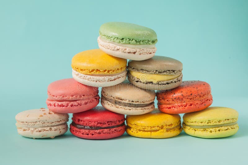 Куча красочных macaroons штабелированных вверх как башня в голубой предпосылке пастели бирюзы стоковое фото rf Куча красочных macaroons штабелированных вверх как башня в голубой предпосылке пастели бирюзы стоковое фото rf