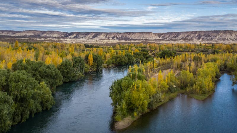 Ландшафт долины осенью Существует огромная река, разделенная на две и большие горные скалы позади стоковое фото rf