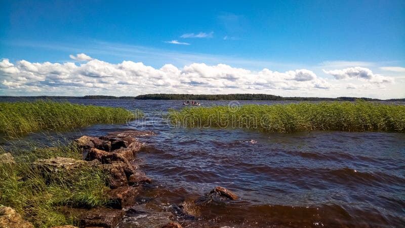 Ландшафт с холодным морем и малой раздувной шлюпкой с рыболовами на волнах стоковые фото Ландшафт с холодным морем и малой раздувной шлюпкой с рыболовами на волнах стоковые фото