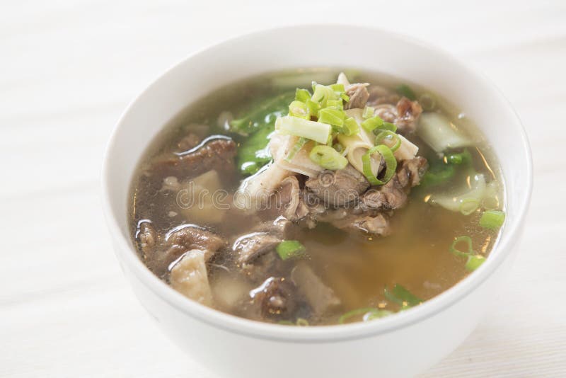 The beef soup with the shallot and the noodle in the bowl . The beef soup with the shallot and the noodle in the bowl .