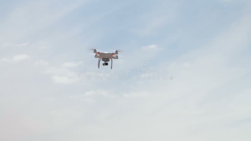 Летание Quadrocopter надземное против голубого неба
