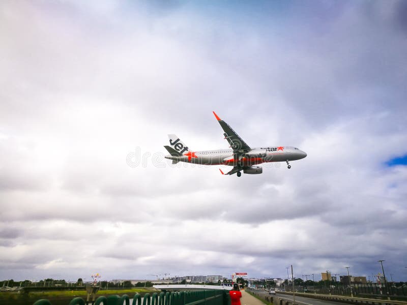 Летание самолета Jetstar на облачном небе над международным аэропортом кузнца kingsford стоковые фотографии rf Летание самолета Jetstar на облачном небе над международным аэропортом кузнца kingsford стоковые фотографии rf