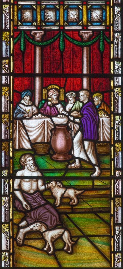 LONDON, GREAT BRITAIN - SEPTEMBER 19, 2017: The Parable of Rich man and Lazarus on the stained glass in St Mary Abbot`s church on Kensington High Street. LONDON, GREAT BRITAIN - SEPTEMBER 19, 2017: The Parable of Rich man and Lazarus on the stained glass in St Mary Abbot`s church on Kensington High Street.