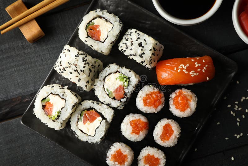 Лоток с вкусными рулетами суши на представлении сверху фона. Японская кухня стоковая фотография