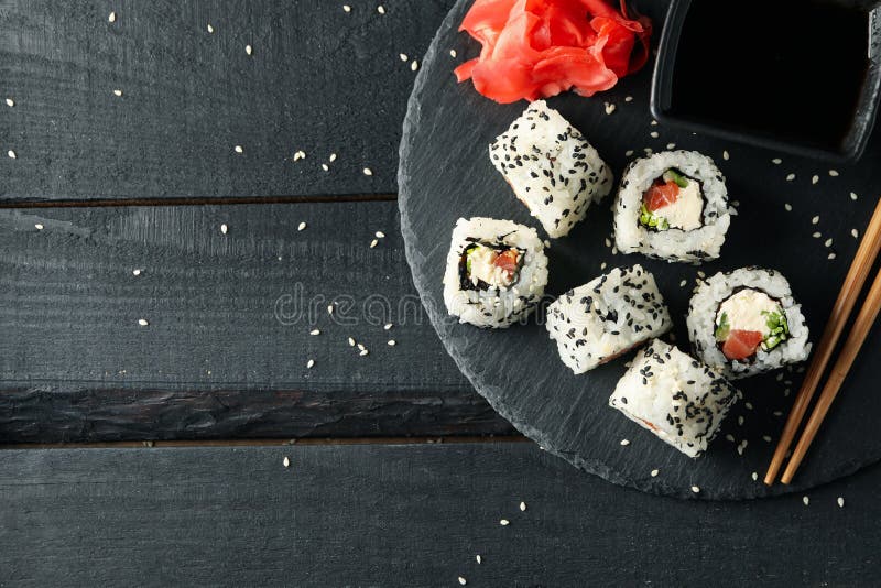 Лоток с вкусными рулетами суши на представлении сверху фона. Японская кухня стоковое изображение rf